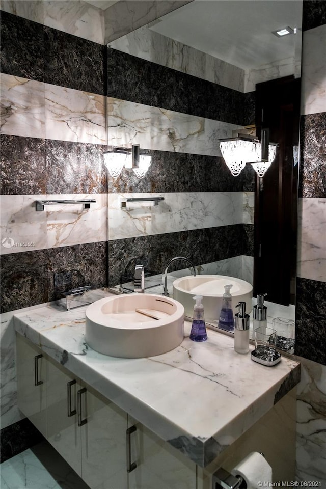 bathroom featuring vanity and tile walls