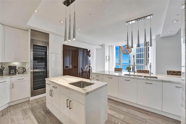 kitchen with a center island with sink, hanging light fixtures, and sink