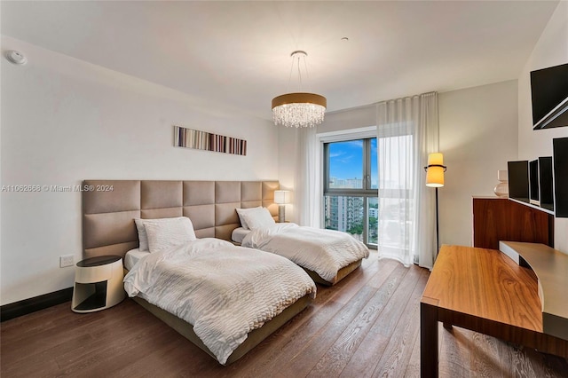 bedroom with a chandelier and dark hardwood / wood-style flooring