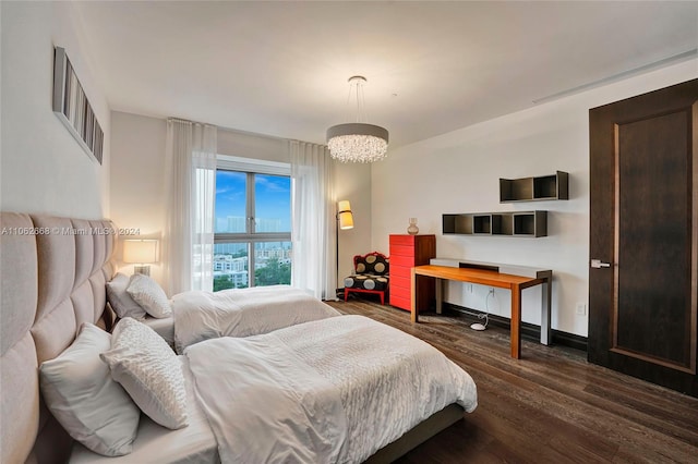 bedroom featuring an inviting chandelier and dark hardwood / wood-style flooring