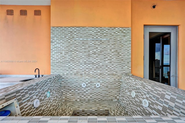 kitchen featuring tile countertops, sink, and tile walls