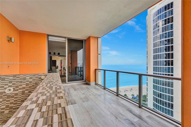 balcony with a water view and a view of the beach