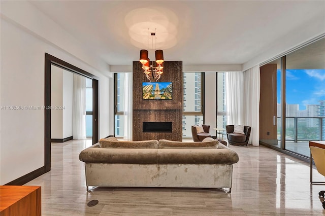 living room with a large fireplace, a chandelier, and floor to ceiling windows