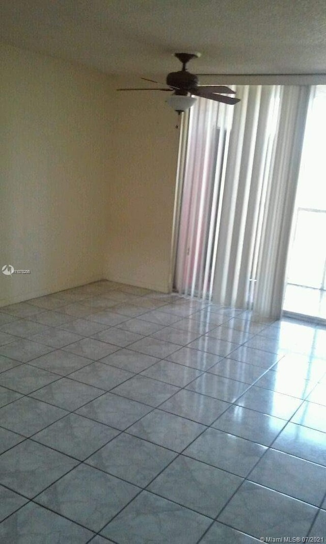 spare room featuring ceiling fan and light tile patterned floors