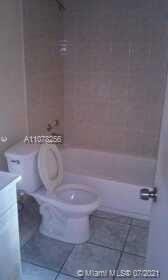 full bathroom featuring tile patterned flooring, tiled shower / bath combo, toilet, and vanity