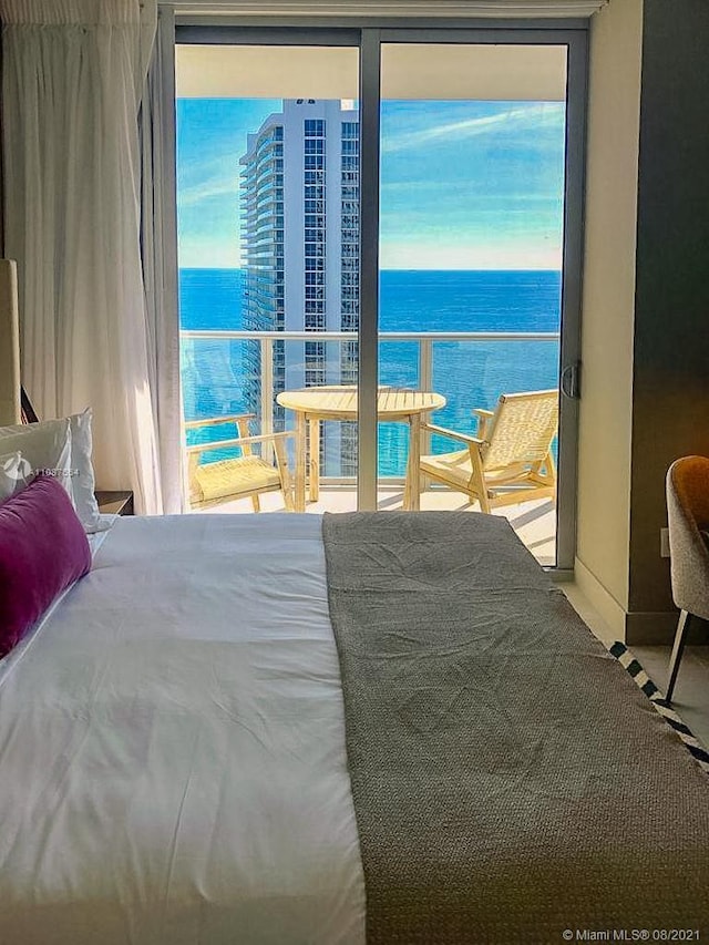 bedroom with a water view and multiple windows