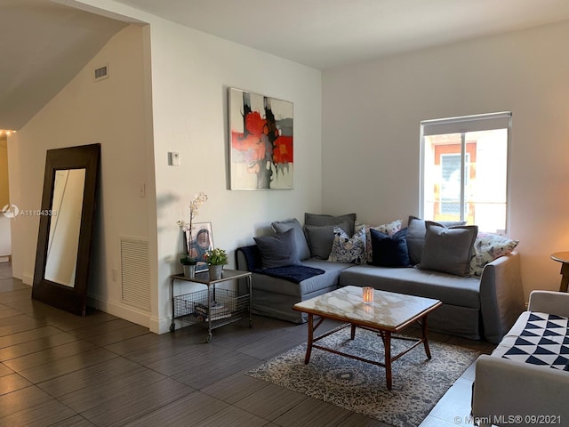 living room with dark tile floors and high vaulted ceiling