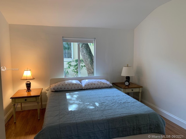 bedroom with dark wood-type flooring