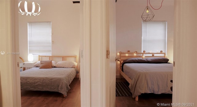 bedroom with a chandelier and dark wood-type flooring