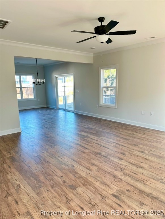 empty room featuring crown molding, plenty of natural light, and hardwood / wood-style floors