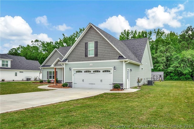 craftsman house with cooling unit, a front lawn, and a garage