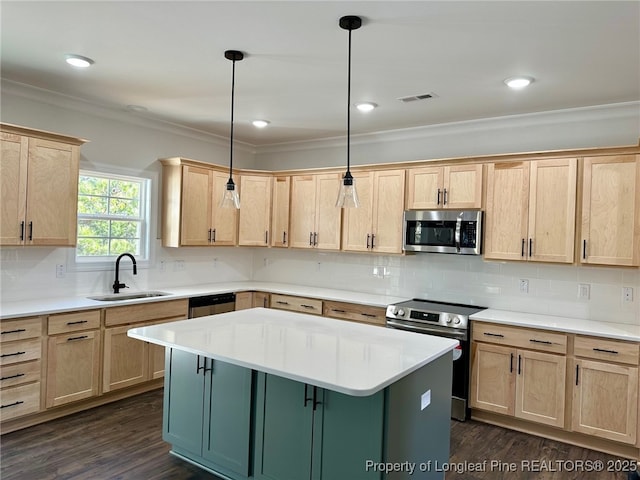 kitchen featuring sink, stainless steel appliances, tasteful backsplash, a kitchen island, and decorative light fixtures