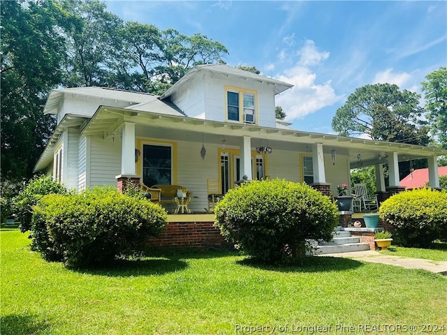 back of property with a porch and a yard