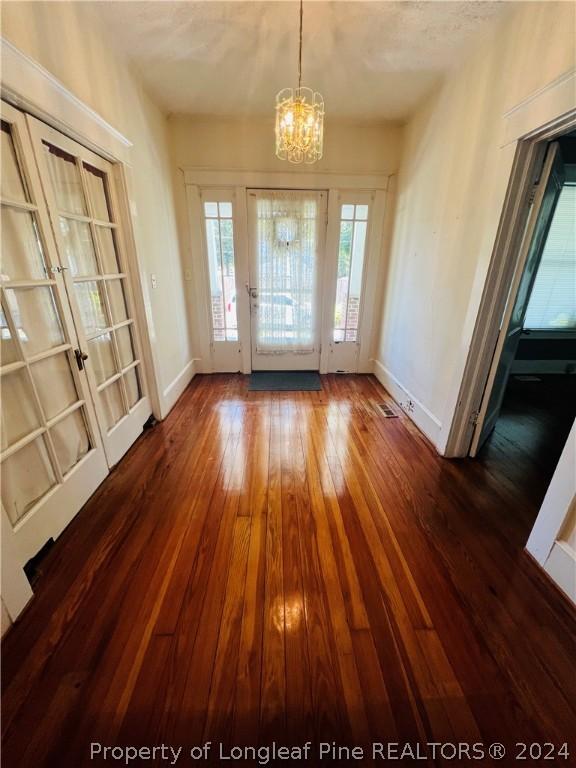 entrance foyer with a chandelier and dark hardwood / wood-style flooring