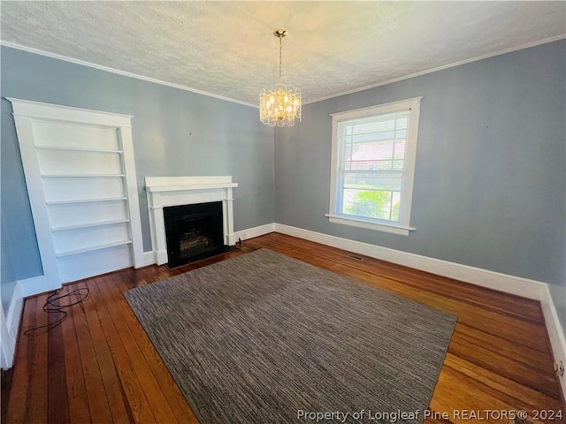 unfurnished living room with a notable chandelier, dark hardwood / wood-style floors, crown molding, and a textured ceiling