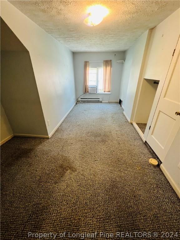 carpeted empty room with cooling unit and a textured ceiling