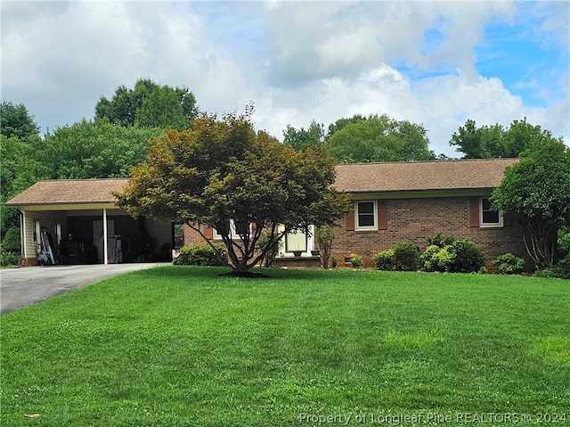 ranch-style home featuring a carport and a front yard