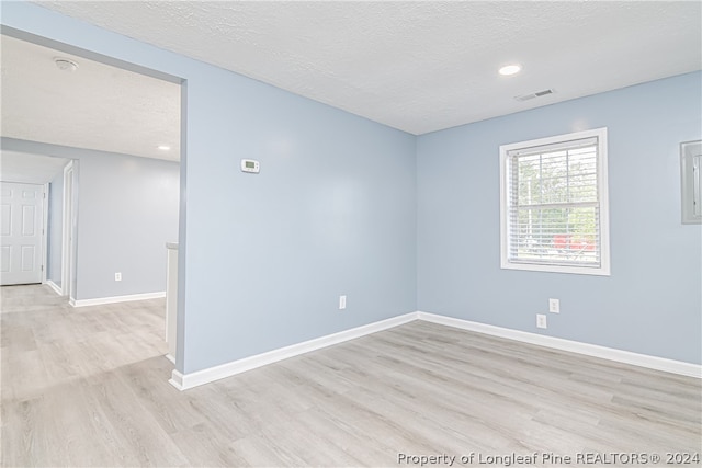 unfurnished room with wood-type flooring and a textured ceiling