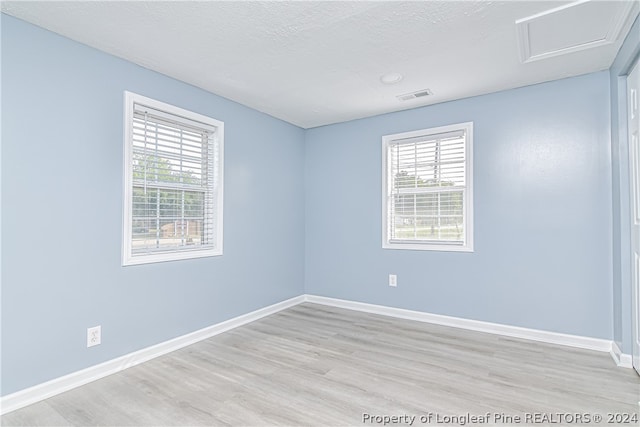 spare room featuring hardwood / wood-style flooring and a wealth of natural light