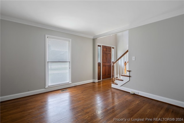 interior space featuring dark wood-type flooring, crown molding, and a healthy amount of sunlight