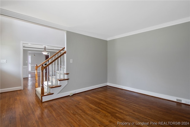 empty room with hardwood / wood-style floors and crown molding