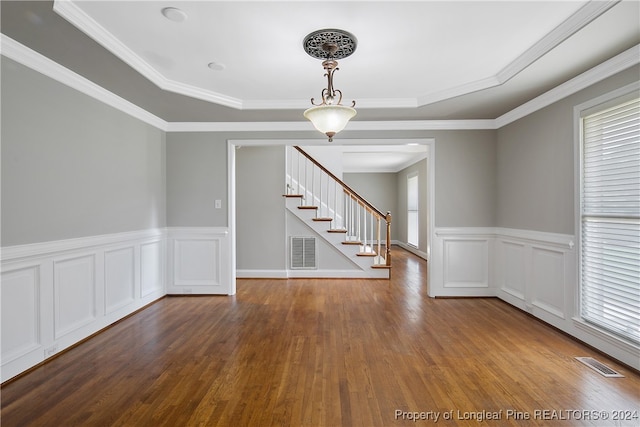 spare room featuring crown molding, hardwood / wood-style floors, and a tray ceiling