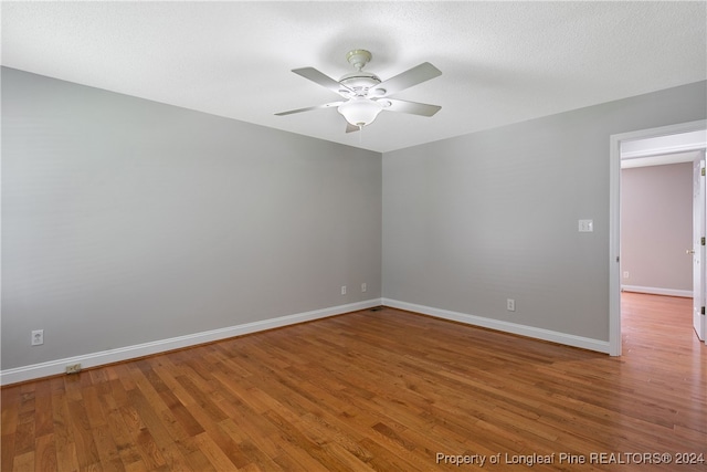 unfurnished room with hardwood / wood-style floors, ceiling fan, and a textured ceiling