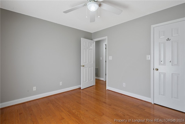 unfurnished bedroom with ceiling fan and hardwood / wood-style flooring