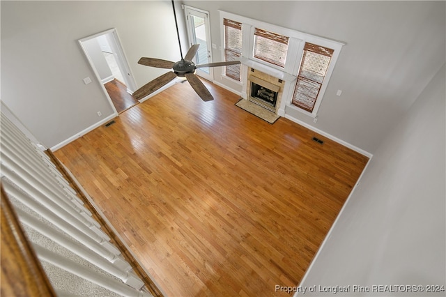 unfurnished living room with ceiling fan and wood-type flooring