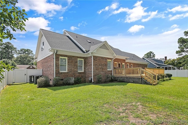 back of house featuring a wooden deck and a lawn