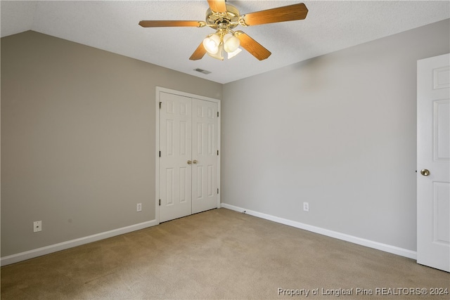 empty room featuring ceiling fan, carpet floors, and vaulted ceiling