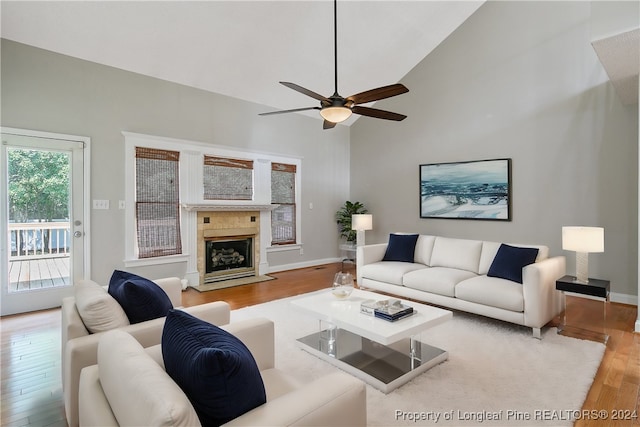 living room featuring a premium fireplace, hardwood / wood-style flooring, high vaulted ceiling, and ceiling fan