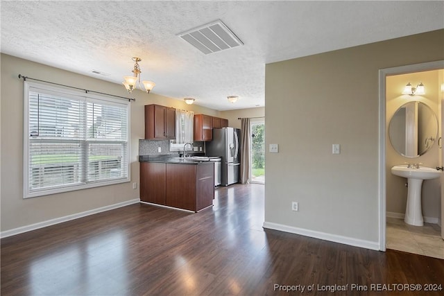 kitchen featuring pendant lighting, sink, tasteful backsplash, dark hardwood / wood-style flooring, and stainless steel fridge with ice dispenser