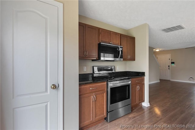 kitchen with dark wood-type flooring, appliances with stainless steel finishes, and a textured ceiling