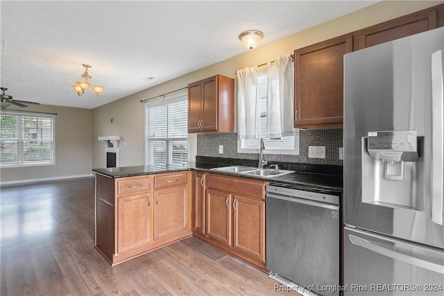 kitchen with stainless steel appliances, tasteful backsplash, sink, and a wealth of natural light