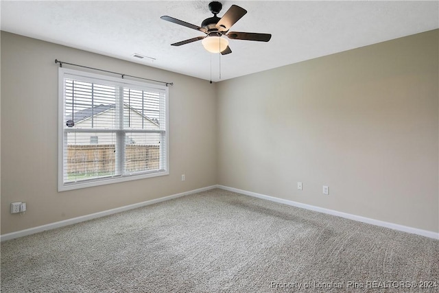 carpeted empty room featuring ceiling fan and a textured ceiling