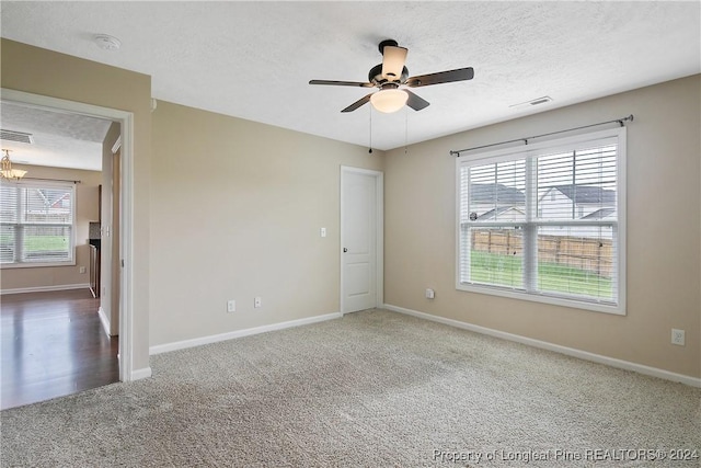 empty room featuring ceiling fan, carpet, and a textured ceiling