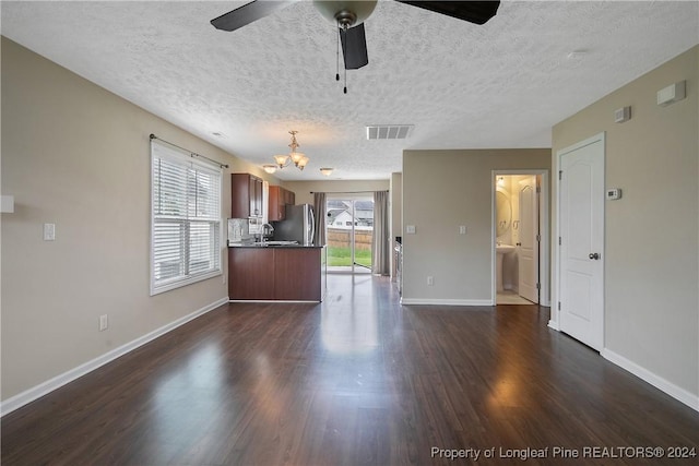 kitchen featuring sink, a textured ceiling, stainless steel refrigerator, dark hardwood / wood-style flooring, and ceiling fan with notable chandelier