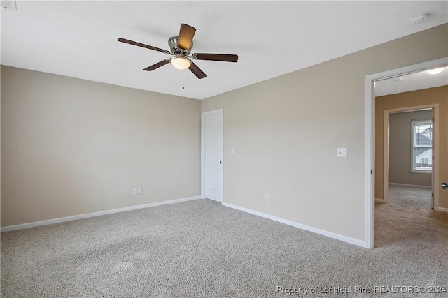 unfurnished room featuring light colored carpet and ceiling fan