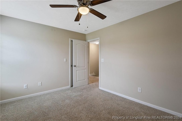 carpeted spare room with ceiling fan