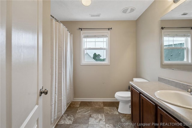 bathroom with vanity, plenty of natural light, and toilet