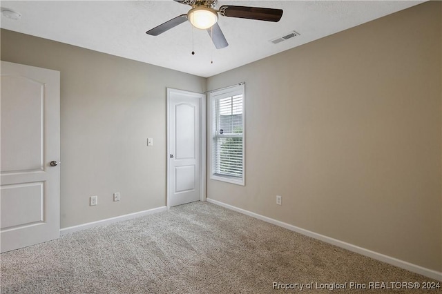 carpeted spare room with ceiling fan