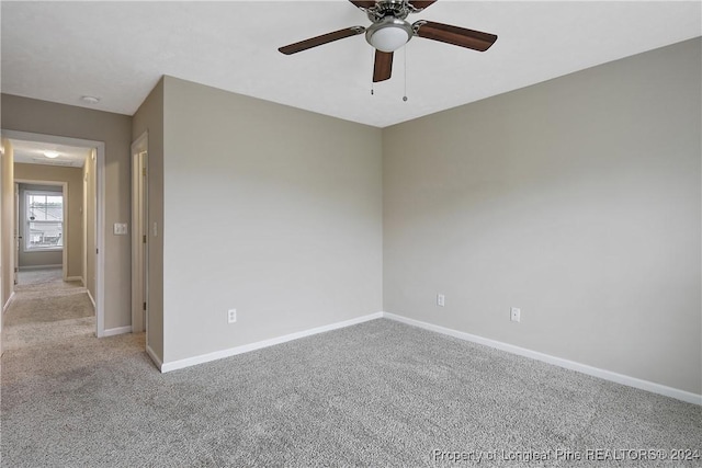 empty room featuring ceiling fan and light colored carpet