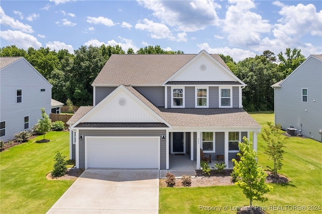 view of front facade featuring a garage, a front lawn, and cooling unit