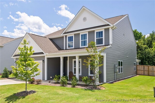 view of front of house with a front lawn, a garage, and covered porch