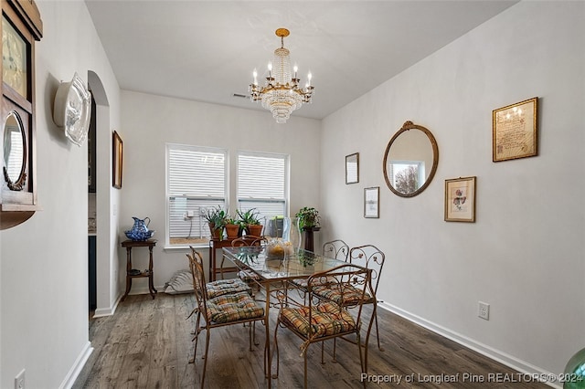 dining area with hardwood / wood-style floors and a chandelier