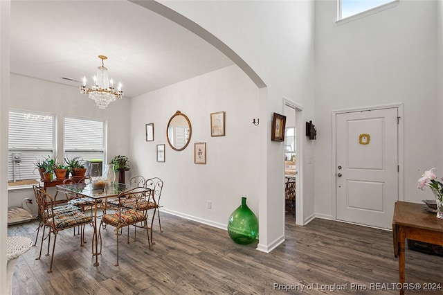 dining space with dark hardwood / wood-style flooring and a notable chandelier