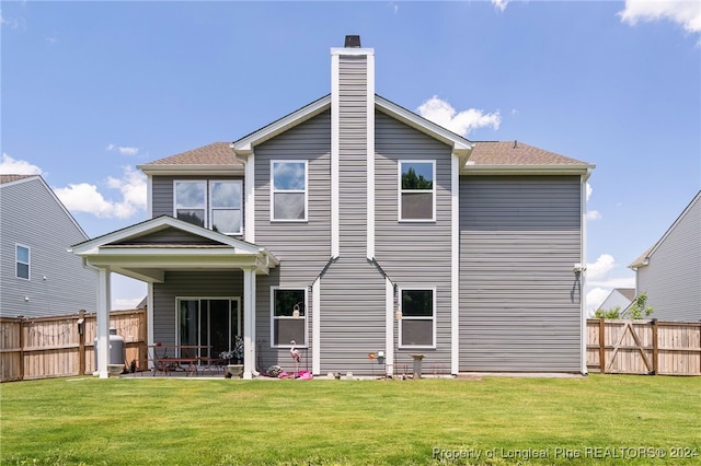 rear view of property with a lawn