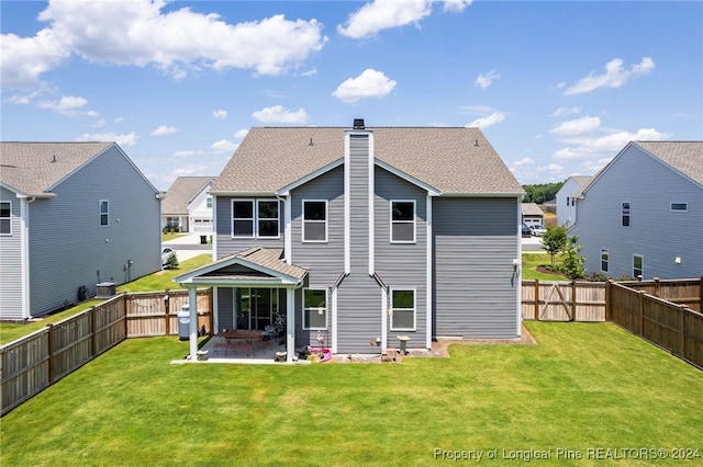 rear view of house featuring a patio area and a yard