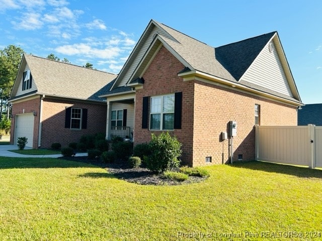 view of side of home with a yard and a garage